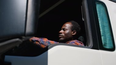 Afrikalı Amerikalı kamyon şoförü takside oturuyor. Kamyon, nakliye, teslimat ve ulaşım kavramı. Kamyoncu yaşam tarzı