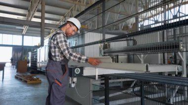 PVC pencere ve kapılarını üretim hattına monte eden el işçisi. Alüminyum ve PVC pencere ve kapı üretim fabrikası