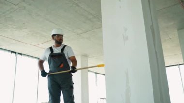 Güvenlik donanımlı bir işçi duvarlara alçı yapıştırıyor.