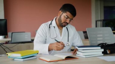 Temizlik şirketinde çalışan Hintli işçiler büyük ofis pencerelerini sprey boya şişesi ve cam sileceği kullanarak temizler. Profesyonel ve lekesiz bir ofis ortamı için temiz pencerelerin korunması şarttır