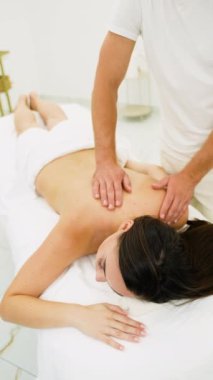 Profesyonel bir masöz kaplıcadaki bir kadına rahatlatıcı bir masaj sağlar. Rahatlatıcı masaj rahatlamayı teşvik eder, stresi azaltır ve huzurlu bir ortamda genel refahı arttırır.