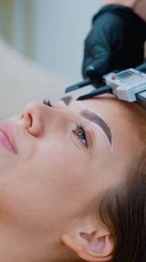 Bir güzellik uzmanı, kalıcı makyaj prosedürüne başlamadan önce kaş simetrisini tam olarak ölçmek için kalibreli kullanır. Kusursuz dengeli ve estetik açıdan memnun kaşlar sağlar.