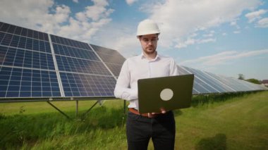 Güneş enerjisi üretimini optimize etmek için verileri analiz eden bir dizüstü bilgisayar üzerinde çalışan Avrupalı mühendis. Yenilenebilir enerji sisteminin verimliliğini sağlamaya odaklanmış durumda.