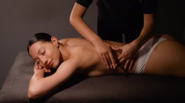 Bir masaj terapisti, bir kadına rahatlatıcı bir sırt masajı sağlar. Sakin bir spa atmosferinde huzur verici ve canlandırıcı bir deneyim yaratarak rahatlama ve refahı arttırır.