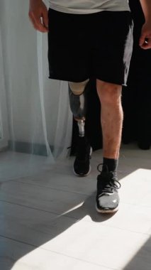 Protez bacaklı bir adam rehabilitasyon yolculuğunun bir parçası olarak yürüme alıştırması yapıyor.