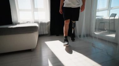 Protez bacaklı bir adam rehabilitasyon yolculuğunun bir parçası olarak yürüme alıştırması yapıyor.