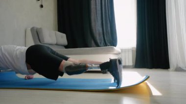 Protez bacaklı bir adam, rehabilitasyon merkezindeki rehabilitasyon programının bir parçası olarak fitness antrenmanına katılır. İyileşme ve güç odaklı