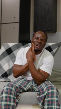 Şiddetli diş ağrısı çeken Afro-Amerikan bir adam çenesini tutuyor ve rahatsızlık veriyor. Bu sahne diş sorunlarının ve rahatlama ihtiyacının altını çiziyor.