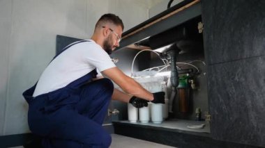 Profesyonel tesisatçı mutfak lavabosunun altına özenle ters osmoz su filtreleme sistemi kurarak arıtılmış içme suyu ve ev suyunun kalitesini arttırıyor.