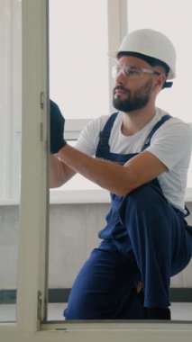 Prezervatif takan odaklı inşaat işçisi modern bir dairede bir kapı çerçevesini hizalayarak istikrar, doğruluk ve kalite uyumunu sağlıyor.