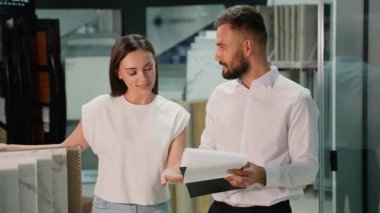 Galeri danışmanı müşteriye rehberlik eder, fayans örneklerini inceler ve müşterinin projeleri için mükemmel bir eşleşme bulduğundan emin olmak için tasarım seçeneklerini tartışır.