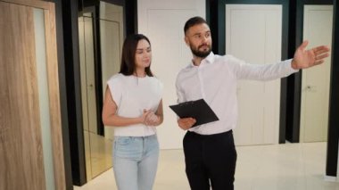 Galeri danışmanı, kadın müşteriye çeşitli kapı seçeneklerinden geçerek ihtiyaçlarına ve tarzına en uygun olanı seçmesinde yardımcı olur.