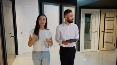 Bir galeri satış danışmanı ve bir müşteri çeşitli kapı seçeneklerini tartışıyor. Danışman, müşterinin bilgilendirilmiş bir karar vermesine yardımcı olmak için uzman görüşleri sağlar.