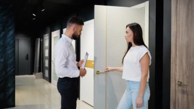 Bir galeri satış danışmanı ve bir müşteri çeşitli kapı seçeneklerini tartışıyor. Danışman, müşterinin bilgilendirilmiş bir karar vermesine yardımcı olmak için uzman görüşleri sağlar.