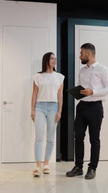 Galeri danışmanı, kadın müşteriye çeşitli kapı seçeneklerinden geçerek ihtiyaçlarına ve tarzına en uygun olanı seçmesinde yardımcı olur.