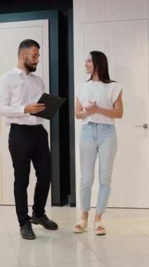 Galeri satış danışmanı bir müşteriyle indirimli kapı seçeneklerini tartışıyor ve ev geliştirme projesi için düşük fiyatlara yüksek kaliteli kapılar bulmasına yardım ediyor.