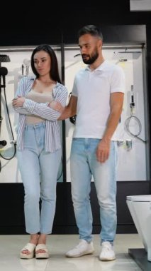 Bir çift, bir galeride çeşitli tuvalet ve tesisat tesisatlarını keşfediyor, banyo tarzlarını ve işlevselliklerini geliştirmek için dikkatlice eşyalar seçiyor.