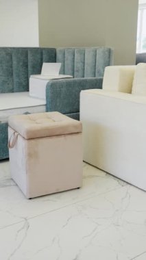 Geniş bir mobilya galerisinde sergilenen şık kanepelerin bir koleksiyonu, bej ve gri renkli aksan yastıklı çağdaş tasarımlar içeriyor.