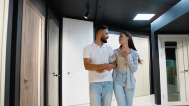Neşeli, yeni evli bir çift kapı showroom 'unda geziniyor, çeşitli kapı stillerini ve yeni evlerinin iç tasarımını mükemmelleştirmek için seçenekleri araştırıyor.