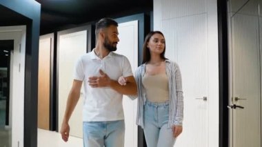 Tarz sahibi bir çift, ev yenileme mağazasında kapı seçeneklerini inceliyor, ev yenileme projeleri için stil ve tasarımları inceliyor.