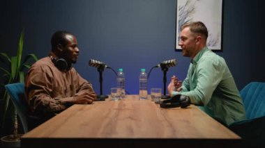 İki blogcu, başarılı bir podcast oturumunu el sıkışarak, tartışmaları ve profesyonel bir stüdyo ortamındaki işbirliğini kutlayarak tamamladı.