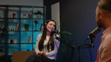 Bir podcast sunucusu kahkahaya boğuldu stand-up komedyeninin esprili şakaları modern bir stüdyoda neşeli ve neşeli bir atmosfer yarattı.