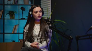 Canlı yayın sırasında bir kadın podcaster 'dan düşünceli bir an. Canlı yayında izleyicileriyle bağlantı kurmak için görüşlerini, fikirlerini ve hikayelerini paylaşıyor.