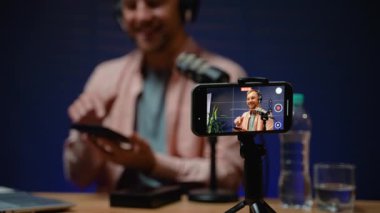 Bir teknoloji blogcusu heyecan verici bir şekilde kameradaki son akıllı telefonu açıyor, takipçileriyle canlı izlenimler ve detaylı görüşleri paylaşıyor.