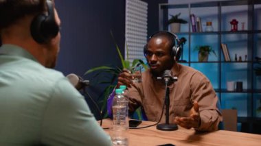 İki çok ırklı blogcu, bir podcast kayıt oturumunda bakış açılarını paylaşıyor, profesyonel bir stüdyo ortamında konuşmaları teşvik ediyorlar.