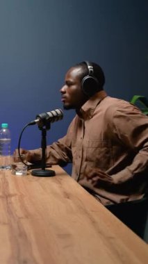 Tutkulu bir podcast sunucusu, modern bir stüdyoda canlı ve ilgi çekici bir konuşma yaratarak, bir kayıt sırasında bir konukla canlı bir şekilde etkileşime geçiyor.