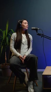 Canlı yayın sırasında bir kadın podcaster 'dan düşünceli bir an. Canlı yayında izleyicileriyle bağlantı kurmak için görüşlerini, fikirlerini ve hikayelerini paylaşıyor.