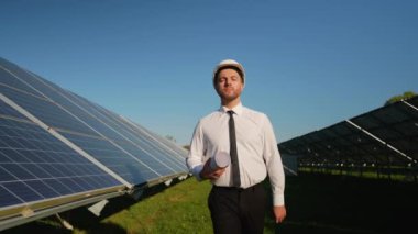 Zırhlı bir mühendis güneş enerjisi santralinde yürüyor, kurulumu denetliyor ve yenilenebilir enerji sistemlerinin en iyi performansını sağlıyor.
