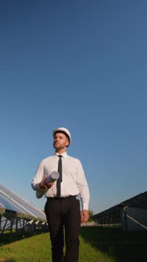 Zırhlı bir mühendis güneş enerjisi santralinde yürüyor, kurulumu denetliyor ve yenilenebilir enerji sistemlerinin en iyi performansını sağlıyor.