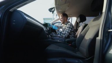 Profesyonel bir araba temizleyicisi, iç mekanın detaylarına odaklanır, gösterge panelini ve direksiyonu titizlikle temizler, lekesiz ve yenilenmiş görünüm sağlar.