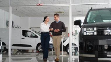 Neşeli yeni evli bir çift, bir araba galerisinde kol kola yürür. İlerideki yolculukları için ilk yeni araçlarını tartışıp seçerler..