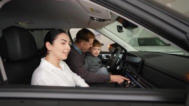 Neşeli bir aile bir galeride yeni bir arabanın içinde oturuyor ve onun özelliklerini test ediyor. Anne ve oğul anın tadını çıkarırken baba kontrollerle etkileşime girer..