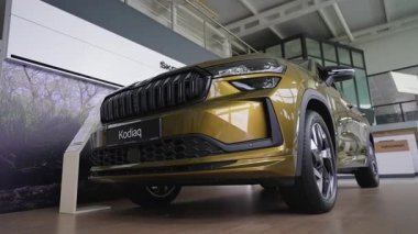 Bir galeri galerisinde yepyeni beyaz bir SUV 'un düşük açılı çekimi, gösterişli ön tasarımı, şık alaşım tekerlekleri ve modern otomotiv özellikleri sergileniyor..