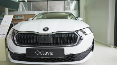 Gıcır gıcır beyaz bir Skoda Octavia galeride sergileniyordu. Arabalar modern ızgara, farlar ve şık tasarım onun şık görünümünü ön plana çıkarıyor..