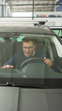 Neşeli bir adam, yeni aldığı arabasında bir galeride oturmuş, heyecanla kutluyor. Yumruklarını kaldırır ve mutluluk içinde dans eder..