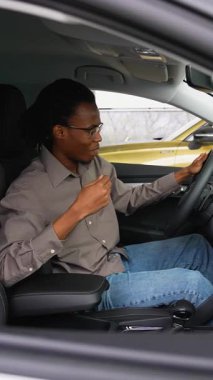 Afro-Amerikalı bir adam yeni aldığı arabasında oturuyor, galerideki Kara Cuma anlaşması için heyecanlı, yeni arabasının keyfini çıkarıyor..