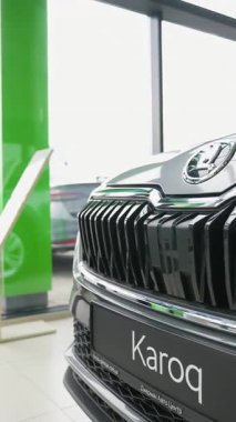 Gıcır gıcır bir galeride sergilenen yepyeni bir aracın arka görüntüsü, parlak tasarımı, arka lambaları ve modern otomotiv özelliklerini ön plana çıkarıyor..