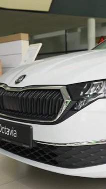 Gıcır gıcır beyaz bir Skoda Octavia galeride sergileniyordu. Arabalar modern ızgara, farlar ve şık tasarım onun şık görünümünü ön plana çıkarıyor..