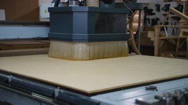 Otomatik CNC makinesi bir mobilya fabrikasında OSB ahşap paneller kesiyor. Ahşap mobilya bileşenleri üretmek için kullanılan hassas endüstriyel süreç.