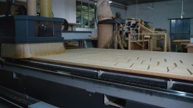 CNC makine yönlendiricisi modern bir ahşap atölyesinde mobilya üretimi için MDF tahtasını kesin dikdörtgen parçalara ayırır.