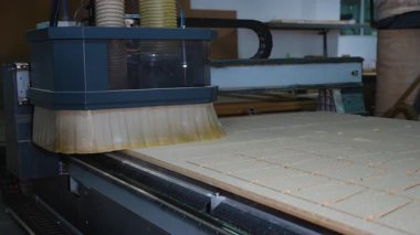 Modern marangozluk fabrikasındaki mobilya üretimi için CNC router 'ın dikdörtgen parçalara ayırdığı yakın çekim görüntüsü.