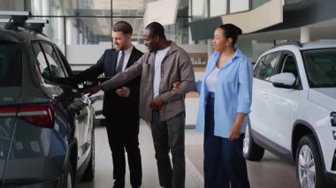 Gösteri odası danışmanı, genç bir Afro-Amerikan çifte yeni bir arabanın özelliklerini gösteriyor. Bir araba galerisini ziyaret ediyor ve doğru kararı vermelerine yardımcı oluyor.