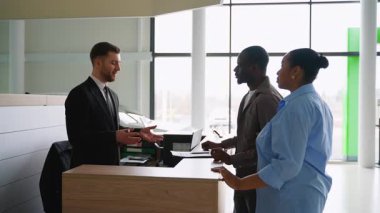 Profesyonel araba satıcısı, Afrikalı Amerikalı çifte evrak işlerinde yardım ediyor ve modern araba galerisinde yeni bir araç satın alıyor. Kutlama sarılması ile sonuçlanıyor.