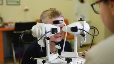 Geniş kapsamlı tıbbi klinik değerlendirmesi sırasında pediatrik dürbün görme ve potansiyel göz durumlarını değerlendiren profesyonel göz doktoru