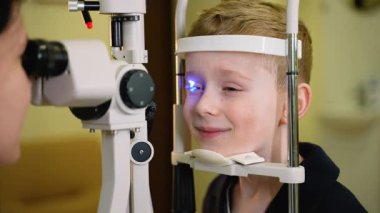 Oftalmolog, göz bebeklerini kesme lambasıyla inceliyor. Optalmolojide insan gözünün ön ve arka kısımlarını incelemek için kullanılan bir teşhis aracı.