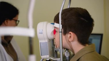 İleri seviye otorefraktör teknolojisi kullanarak genç hasta üzerinde hassas görüş değerlendirmesi yapan yetenekli bir optometrist.